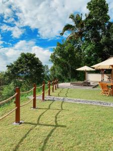 uma cerca ao lado de um quintal com mesas e guarda-chuvas em Besakih Homestay & Villa em Besakih