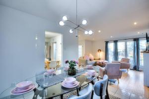 una sala da pranzo e un soggiorno con tavolo e sedie. di Style & Comforts by Montreal - New - 3BR Bungalow a Candiac
