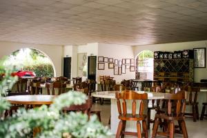 Hostal Chez Holman في San Luis: غرفة طعام مع طاولات وكراسي ونوافذ