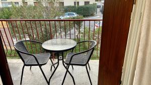 a table and two chairs on a balcony at Appart Cosy sur Salon de Provence in Salon-de-Provence