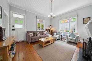 a living room with a couch and a table at Trefusis Cottage in Blackheath