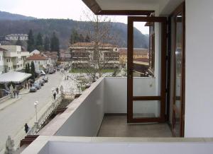 a door to a balcony with a view of a street at Apartment Planinski Rai in Tryavna