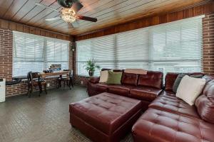 a living room with a leather couch and a table at Beautiful 5BR/4BA Luxury Historic Home on Success in Lakeland