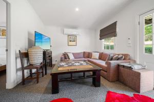 a living room with a couch and a table at Tukidale Cottage - 3BR Cottage l WiFi l Air-Con l Relaxing Location in Crackenback
