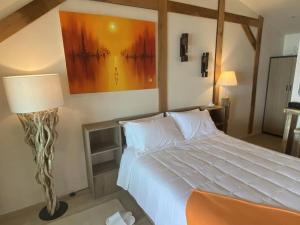 Un dormitorio con una gran cama blanca y una lámpara en Nam Jai Beach Bungalow - Tropical en Nathon Bay