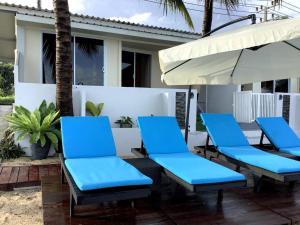 - un ensemble de chaises bleues et un parasol sur la terrasse dans l'établissement Nam Jai Beach Bungalow - Tropical, à Nathon Bay
