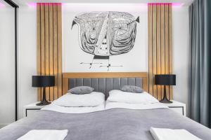 Schlafzimmer mit einem Bett mit Wandzeichnung in der Unterkunft Apartamenty Polanowscy Baltic Marina Residence z mini SPA przy Bałtyckiej in Kołobrzeg