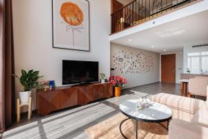 a living room with a couch and a tv at Muse Hanoi PentStudio West Lake in Hanoi