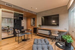 a living room with a tv and a table and chairs at Cyclinn Vila Olímpia in São Paulo