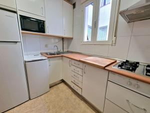 a small kitchen with white cabinets and a sink at Reina Cristina, 3 dormitorios individuales en Atocha-Retiro in Madrid