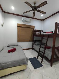 1 Schlafzimmer mit 2 Betten und einem Deckenventilator in der Unterkunft บ้านเพื่อน 44 พลูวิวล่า in Bang Sare