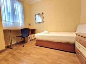 a bedroom with a bed and a desk and a table at Reina Cristina, 3 dormitorios individuales en Atocha-Retiro in Madrid