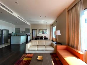 a living room with a couch and a kitchen at Marriott Executive Apartments - Sukhumvit Park, Bangkok in Bangkok