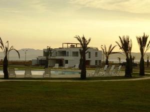 a building with chairs and a swimming pool in a park at Nuevo Paracas in Paracas