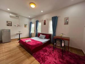a bedroom with a bed and a red rug at The Hub Kampot in Kampot