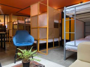 a room with bunk beds and a blue chair at Hostel Cowork en Chapinero in Bogotá