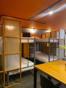 um quarto com três beliches e uma mesa em Hostel Cowork en Chapinero em Bogotá