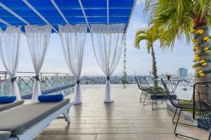 a balcony with white curtains and a view of the water at SEA QUEEN Hotel in Da Nang