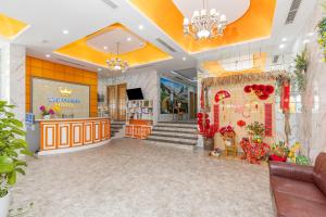 un vestíbulo de una tienda con una escalera y flores en SEA QUEEN Hotel, en Da Nang