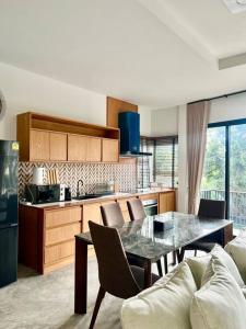 a kitchen and dining room with a table and chairs at Villa 173 - Two bedroom private villa in Ban Pak Chong Noi