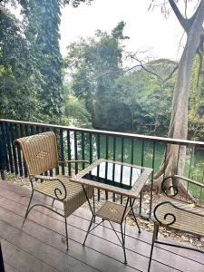 a table and two chairs on a wooden deck at Villa 173 - Two bedroom private villa in Ban Pak Chong Noi
