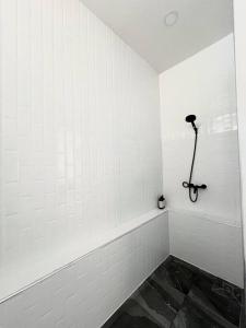 a bathroom with white walls and a black tile floor at Villa 173 - Two bedroom private villa in Ban Pak Chong Noi