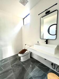 a bathroom with a sink and a toilet and a mirror at Villa 173 - Two bedroom private villa in Ban Pak Chong Noi