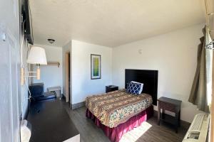 une chambre d'hôtel avec un lit et une lampe dans l'établissement Luxury Inn By OYO Albany, à Albany