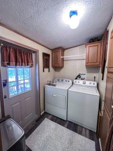 a small kitchen with a washer and dryer at Bern's Summit Solitude: Stream-Front Serenity in Confluence