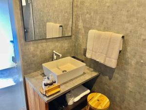 een badkamer met een wastafel, een spiegel en handdoeken bij レドンド秋吉台 