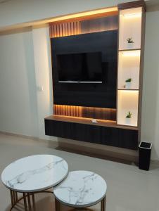 twee tafels en een televisie in een kamer bij Classy and Elegance Apartment at Meikarta Tower Silverlake 