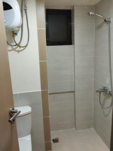 een badkamer met een douche, een toilet en een televisie bij Classy and Elegance Apartment at Meikarta Tower Silverlake 