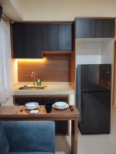 een keuken met een houten tafel en een koelkast bij Classy and Elegance Apartment at Meikarta Tower Silverlake 