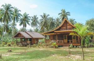 una pequeña casa de madera con palmeras en el fondo en Kohjum Freedom Resort, en Ko Jum
