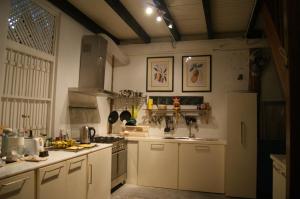 a kitchen with white cabinets and a stove top oven at Experience Island Heritage Home in Pantai Kok