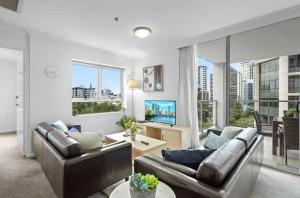 a living room with two couches and a tv at Cozy Unit in the heart of Brisbane in Brisbane