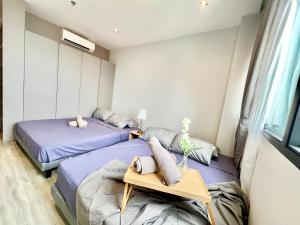 a bedroom with two beds and a table in it at LB Cozy Home 1-10Pax 3Room Tropicana 4QBeds BalconyTV in Petaling Jaya +27 photos