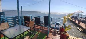 羅阿坦的住宿－Victoria s Beach House and Snorkeling Center，一个带桌椅的海景阳台