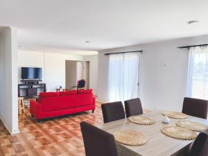 sala de estar con mesa y sofá rojo en Cabaña con piscina, en Peralillo