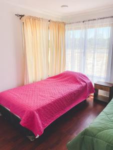 sypialnia z różowym łóżkiem i oknem w obiekcie Cabaña con piscina w mieście Peralillo