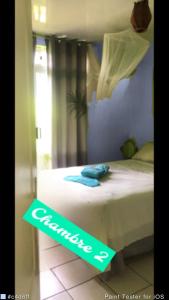 a bedroom with a bed with a sign on it at A louer chambres Blue 2 personnes raiatea in Taputapuapea