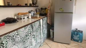 a kitchen with a counter with a microwave and a refrigerator at A louer chambres Blue 2 personnes raiatea in Taputapuapea
