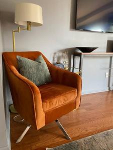 a brown chair with a pillow in a living room at Entire Home Downtown ATL! Walk to GWCC and more! in Atlanta