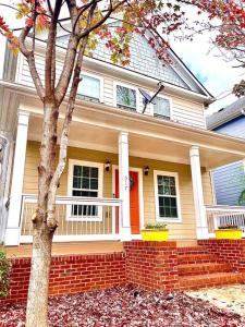 a house with a red door and a tree at Entire Home Downtown ATL! Walk to GWCC and more! in Atlanta