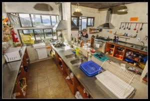 a woman in a kitchen with a counter top at Hospedaje Penthouse 1004 in San Carlos de Bariloche +33 photos