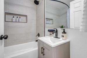 a white bathroom with a sink and a bath tub at Spacious Remodeled Retreat Haven in Las Vegas
