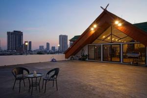 Deux chaises et une table sur le toit d'un bâtiment dans l'établissement Rooftop Paradise & Koi Pond-6BR Hideaway@Icon Siam, à Bangkok