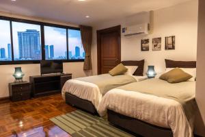um quarto com 2 camas e uma grande janela em Rooftop Paradise & Koi Pond-6BR Hideaway@Icon Siam em Bangkok