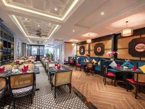 um restaurante com mesas e cadeiras num quarto em Hue Serene Palace Hotel em Hue