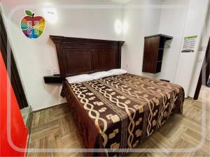 ein Bett in einem Zimmer mit einem Apfel an der Wand in der Unterkunft HOTEL LA GRAN MANZANA in Zacatlán
